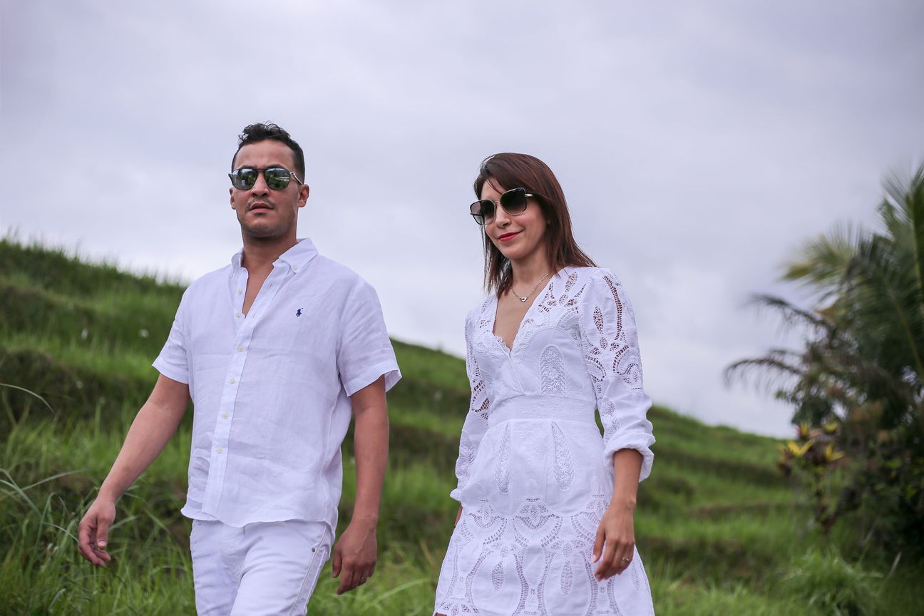 A family dressed in white walk the paths between the rice terraces